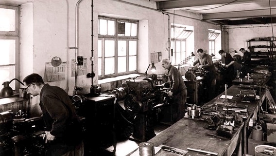 An old black and white photo showing several men on machines in the workshop © Lutz Bertram Photo: Lutz Bertram