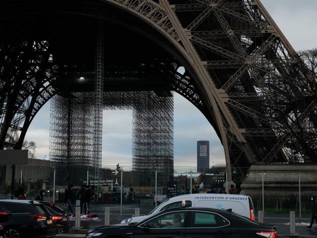 Cars in front of the Eiffel Tower.