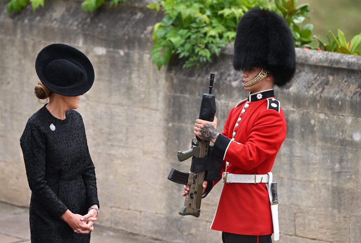 A mourner surveys a member of the Coldstream Guard outside Windsor Castle.  (September 19, 2022)