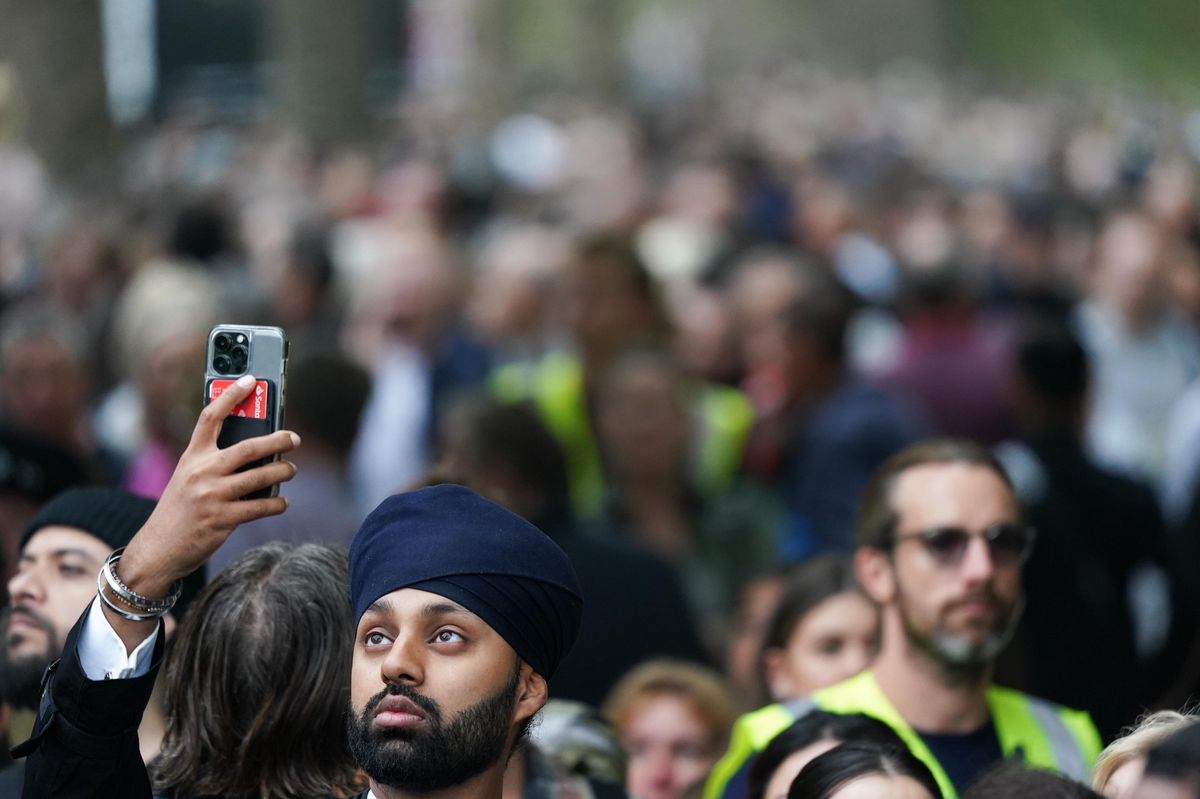 Memories: A man photographs crowds bidding farewell to the Queen on the streets of London.  (September 19, 2022) 