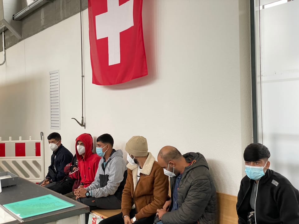 Migrants sitting in the waiting room.